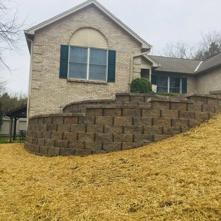Curved segmental block retaining wall beside a brick home Curved segmental block retaining wall beside a brick home